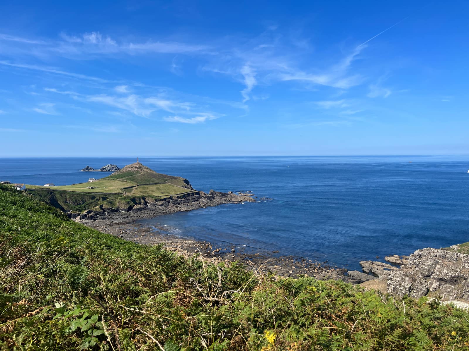 Cape Cornwall headland and its chimney seen from the coast path on a clear summer day