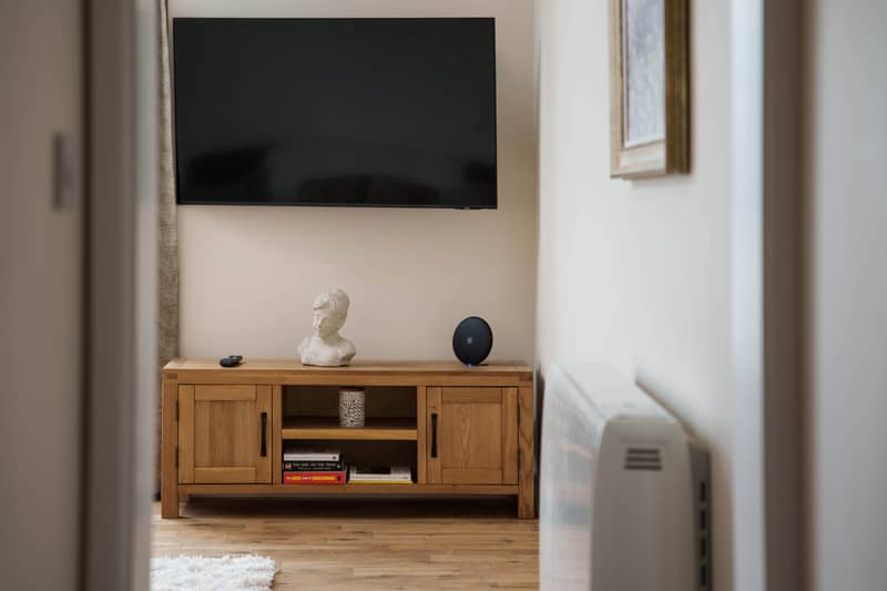 Wall-mounted smart TV above an oak media unit