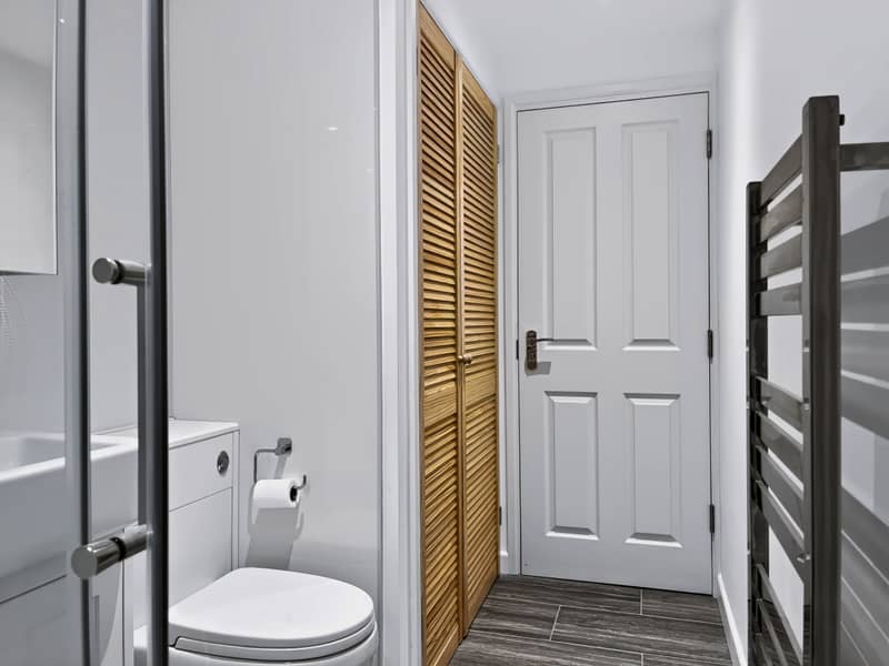 Bathroom with walk-in shower, heated towel rail and louvred storage