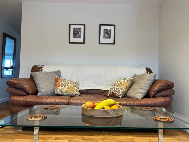 Leather sofa with cushions and throw in The Loft's sitting area
