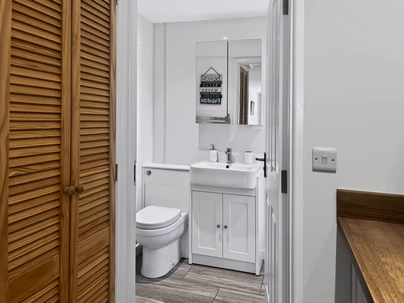 Bathroom with basin vanity and mirrored cabinet, off the upstairs kitchen
